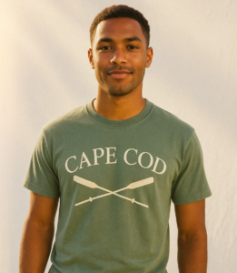 young man wearing a short sleeve tee shirt with an illustration of crossed oars and the text Cape Cod on it