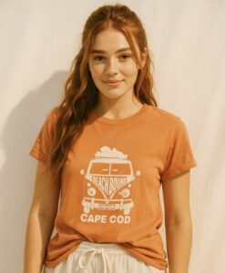 young woman wearing crimson tee shirt with the illustration of a Volkswagen beach bus and the text Cape Cod on it